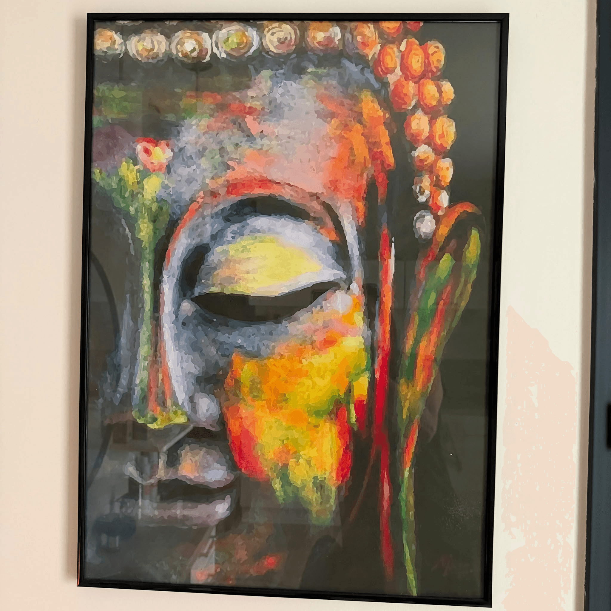 Peinture colorée d'un visage de Bouddha, accrochée près de l'entrée